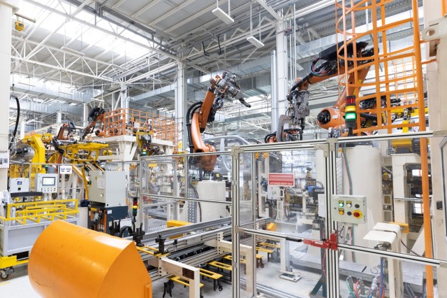 Photo of automobile production line. Welding car body. Modern car assembly plant. Auto industry. Interior of a high-tech factory, modern production